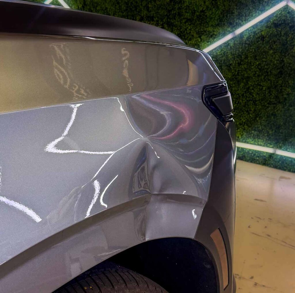 2025 Cadillac Escalade front fender with a large dent before Paintless Dent Repair (PDR
