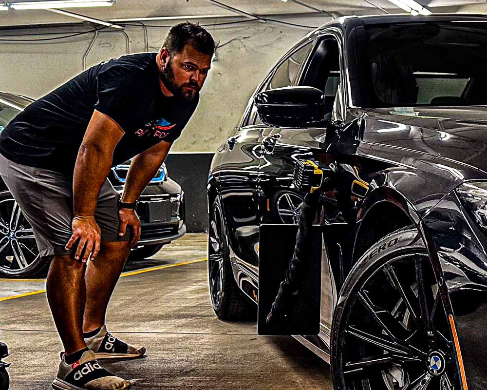 Jacob from Patriot Dent Repair performing mobile paintless dent repair on a vehicle in Phoenix, Arizona