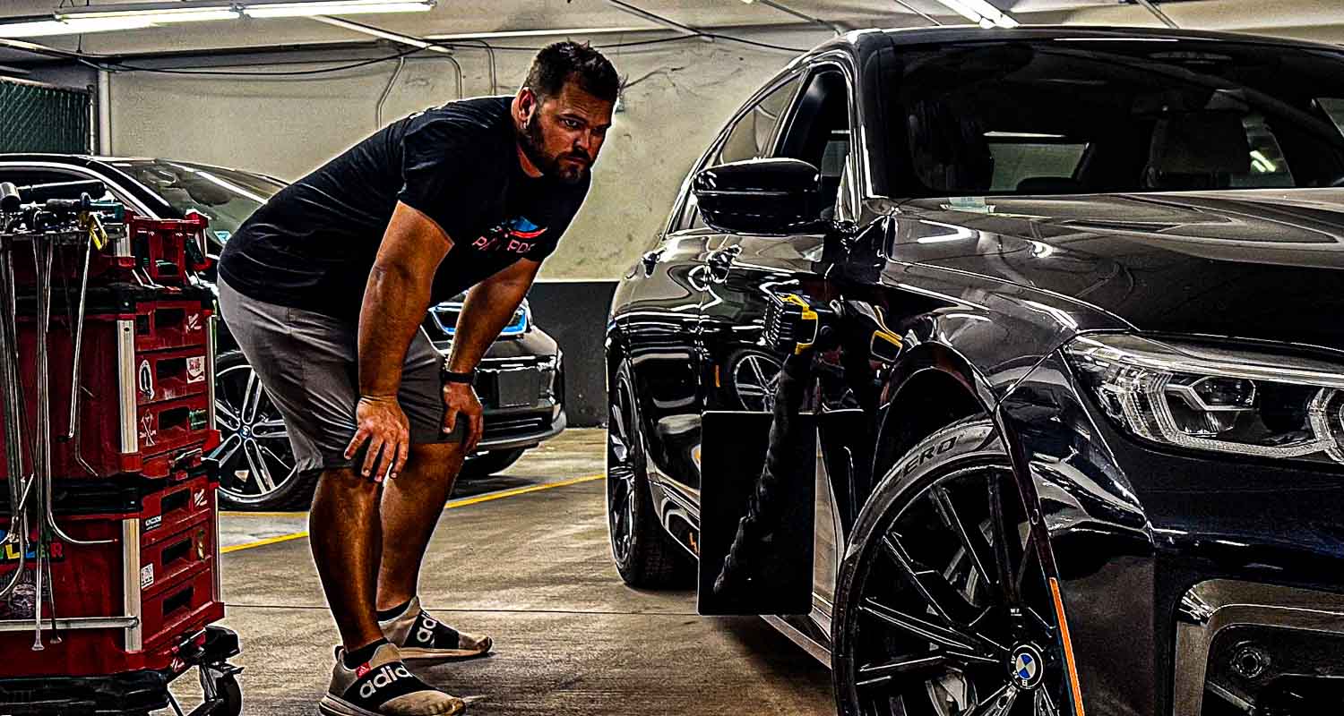 Patriot PDR owner inspecting a dent on a vehicle in Phoenix, Arizona